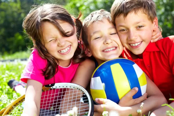 three-children-with-sports-equipment-embracing-1